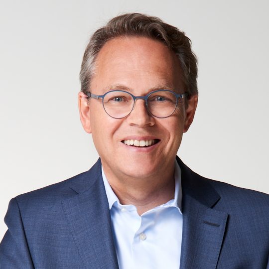 Eine Person in einem blauen Anzug und einem weißen Hemd.