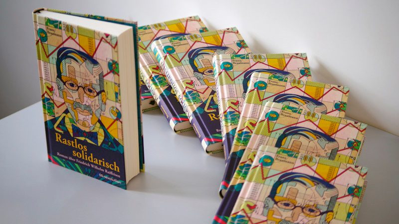 Das Bild stellt das Cover eines Buches dar. Der Titel des Buches lautet "Rastlos solidarisch", und es handelt sich um einen Roman über Friedrich Wilhelm Raiffeisen. Auf dem Cover ist eine Illustration, die wahrscheinlich Raiffeisen darstellt, umgeben von verschiedenen Symbolen, die möglicherweise seine Ideale oder seine Errungenschaften widerspiegeln. Der Autor des Buches ist Tilman Röhrig.**Zusammenfassung:**- **Titel:** Rastlos solidarisch- **Untertitel:** Roman über Friedrich Wilhelm Raiffeisen- **Autor:** Tilman Röhrig- **Motive:** Illustration einer Person, vielerlei SymboleFriedrich Wilhelm Raiffeisen war ein wichtiger deutschen Sozialreformer und einer der Begründer des Genossenschaftswesens. Sein Leben und Werk könnten zentrale Themen des Romans sein.