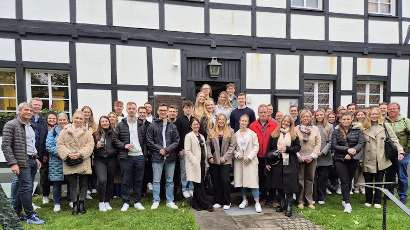 Das Bild zeigt eine große Gruppe von Menschen, die vor einem Fachwerkhaus , dem Raiffeisenmuseum in Hamm, stehen.